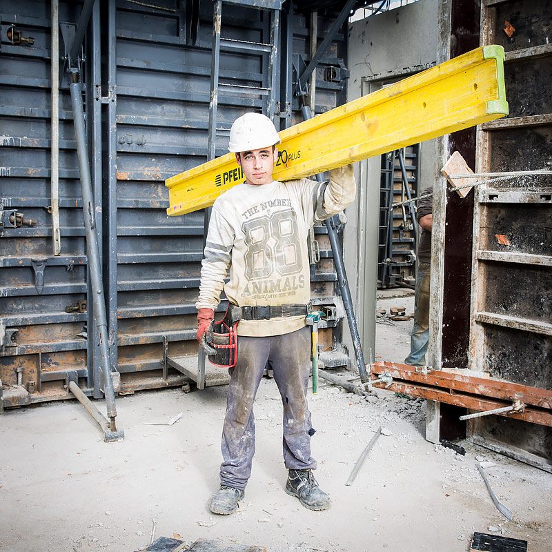 Portrait d'un maçon sur un chantier de construction d'un batiment d'habitation par une photographe d'architecture