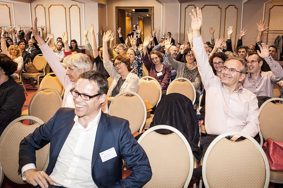 Managers raising their arm participating in a seminar at Dream Castle Hôtel in Marne-La-Vallée photographed by Denis Dalmasso french photographer